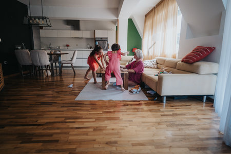 Mother playing with children in cozy living roomの写真素材