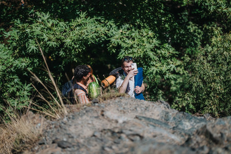 Friends capturing outdoor moments during a scenic nature hikeの写真素材