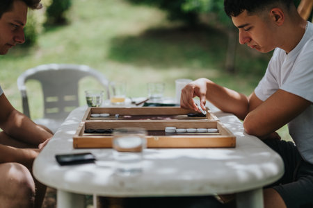 Two friends enjoying an outdoor board game on a sunny dayの写真素材