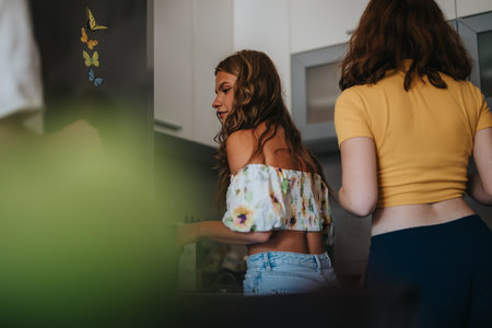 Young women enjoying casual conversation in a home kitchen settingの写真素材