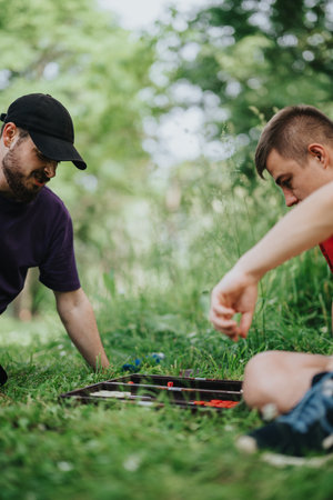 Two friends enjoying a board game in sunny park settingの写真素材