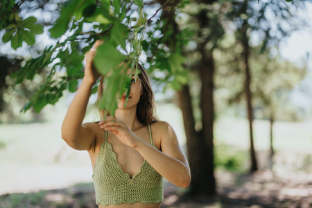 Young woman enjoying a sunny day in the park, embracing nature and outdoor adventureの写真素材