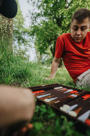 Young man enjoying a board game outdoors in natureの写真素材