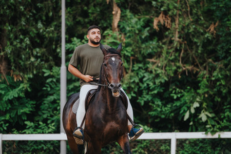 Man riding a horse outdoors in a serene green natural setting during summertimeの写真素材