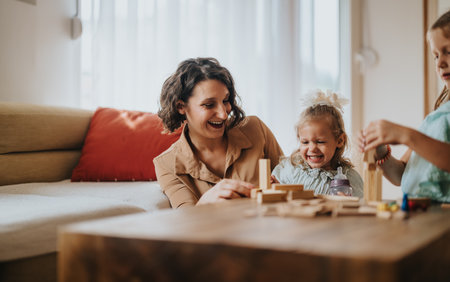 Mom and daughters enjoying a fun afternoon playing together indoorsの写真素材