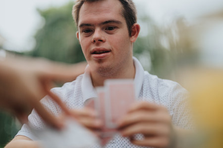 Playful card game with boy and friends outdoorsの写真素材