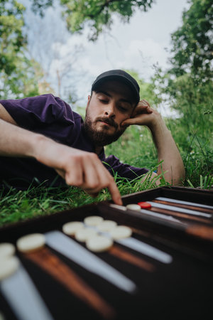 Man playing backgammon in a serene outdoor settingの写真素材