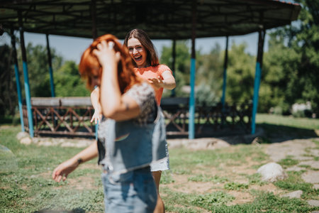 Friends enjoying a sunny day in the park and having fun togetherの写真素材