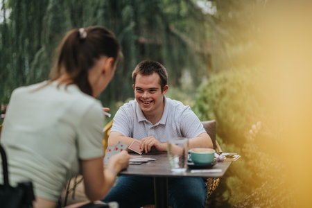 Happy friends playing cards in a cozy outdoor settingの写真素材