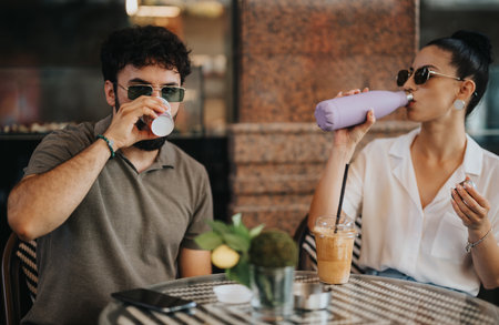 Casual business meeting in coffee shop with colleagues enjoying drinksの写真素材