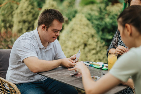 Young man enjoying a friendly card game outdoorsの写真素材