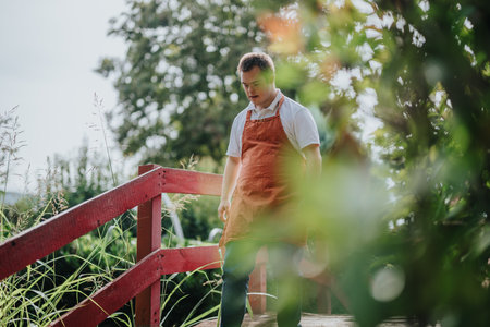 Young man enjoying a peaceful garden strollの写真素材