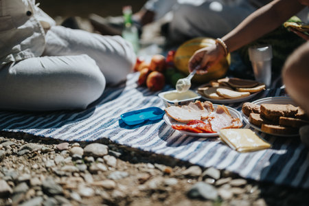 Close-up of a picnic scene with diverse food and people enjoying outdoors