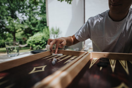 Young man playing backgammon outdoors on a sunny dayの写真素材