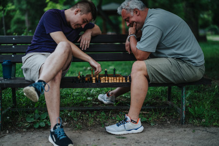 Father and son enjoying a chess match on a park bench