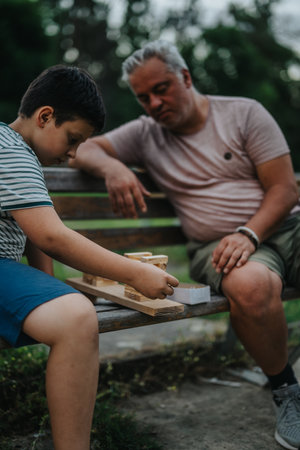 Father and son bonding through building blocks in park