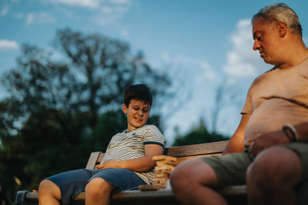 Father and son playing building blocks in the park on a sunny dayの写真素材