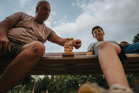 Father and son playing with building blocks in the park