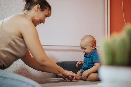 Mother and baby playing together indoors, bonding and learningの写真素材