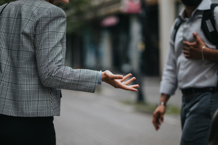 Close-up of business interaction outdoors with man and woman in conversationの写真素材