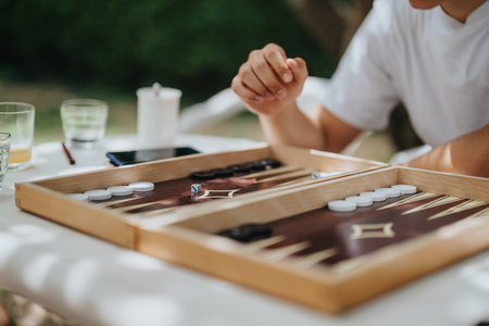 Person playing backgammon outdoors on a sunny dayの写真素材