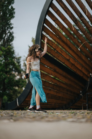 Joyful young girl enjoying music while dancing outdoorsの写真素材
