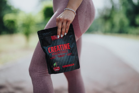 Close-up of hand holding supplement packet while standing outdoors.の写真素材