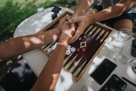Two people enjoying a backgammon game outdoors in sunny weatherの写真素材