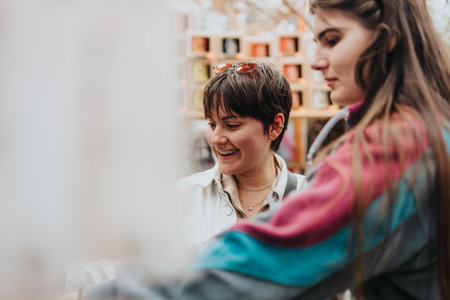 Two women smiling and bonding in cozy indoor settingの写真素材