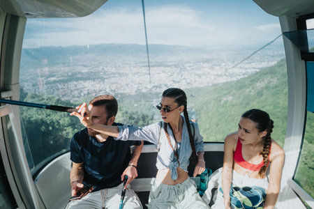 Friends enjoying scenic view from cable car ride in mountains on vacationの写真素材