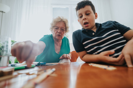 Grandmother and grandson playing a board game at homeの写真素材