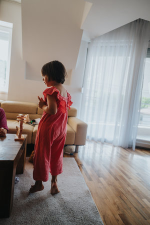 Child playing happily at home in a bright living roomの写真素材