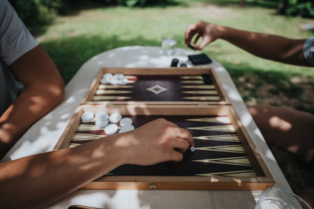 Two people playing backgammon outdoors on a sunny dayの写真素材