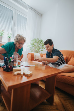 Grandmother and grandson enjoying a board game together in living room