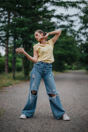 Girl enjoying herself alone in the park with a playful poseの写真素材