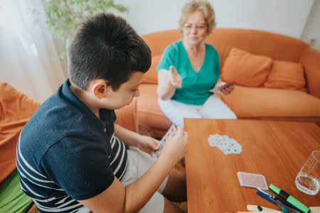 Grandmother and grandson enjoying card game at home togetherの写真素材