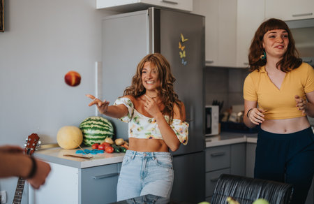 Friends enjoying a playful moment in a modern kitchenの写真素材