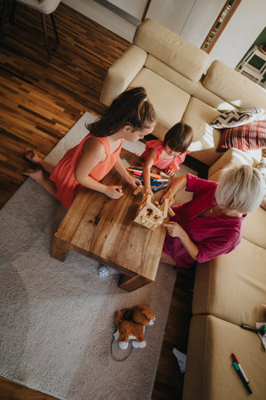 Mother and grandchildren playing with blocks in cozy living roomの写真素材