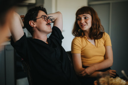 Casual friends enjoying a relaxed conversation at home while sharing a moment togetherの写真素材