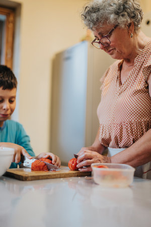 Grandmother and grandson cooking together in the kitchenの写真素材