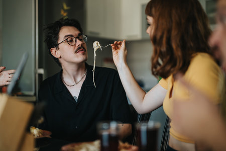 Couple enjoying a playful pasta dinner at home together