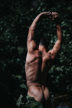 Muscular man stretching in nature showcasing strength and serenityの写真素材