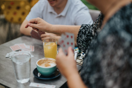 Playing cards with friends over coffee and juiceの写真素材