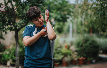 Young girl interacting with vibrant snakes in a lush garden