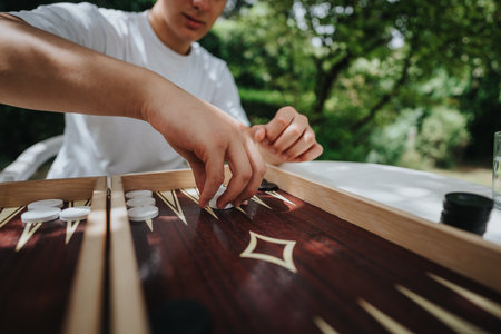 Person playing backgammon outdoors on a sunny day in the garden