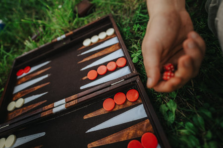 Close-up of backgammon game outdoors with player holding diceの写真素材