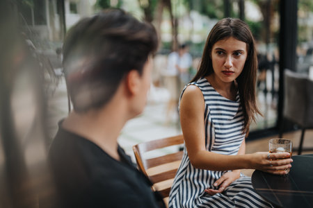 Young couple having a serious conversation at outdoor cafeの写真素材