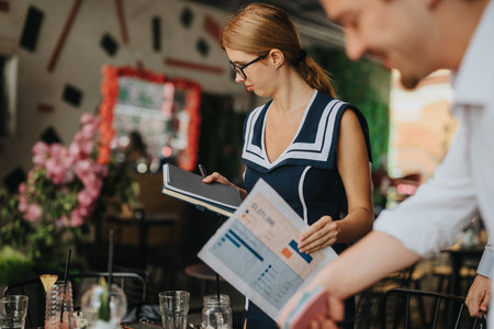 Business meeting in a creative outdoor cafe setting with documentsの写真素材