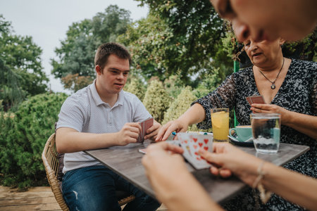 Family enjoying a card game outdoors on a sunny dayの写真素材