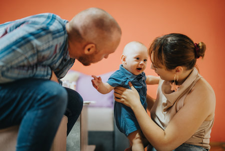 Parents lovingly interacting with their smiling baby at home